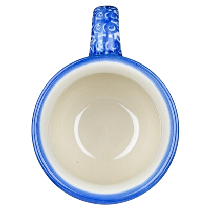 Unikat Polish pottery Boleslawiec mug with a blue handle and intricate design inside