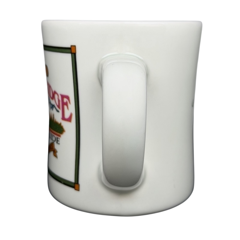 Side view of a vintage G.H. Bass mountain ridge mug with colorful design and sturdy handle