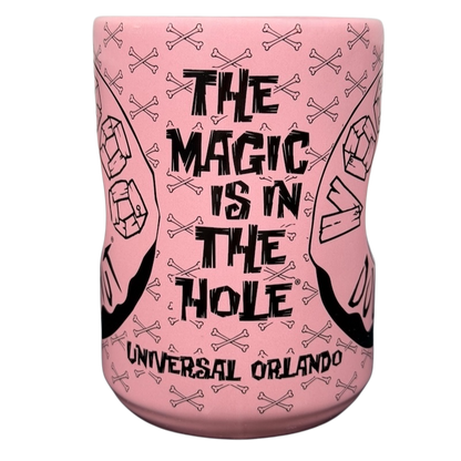 Voodoo Doughnut Universal Orlando mug with pink design and bold text featuring skulls and crossed bones