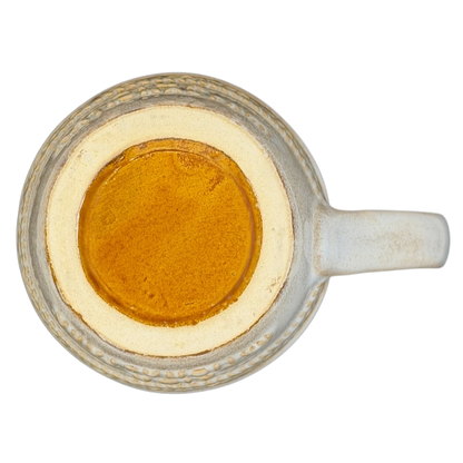 Top view of a rustic Zion National Park mug with a textured design and golden liquid inside